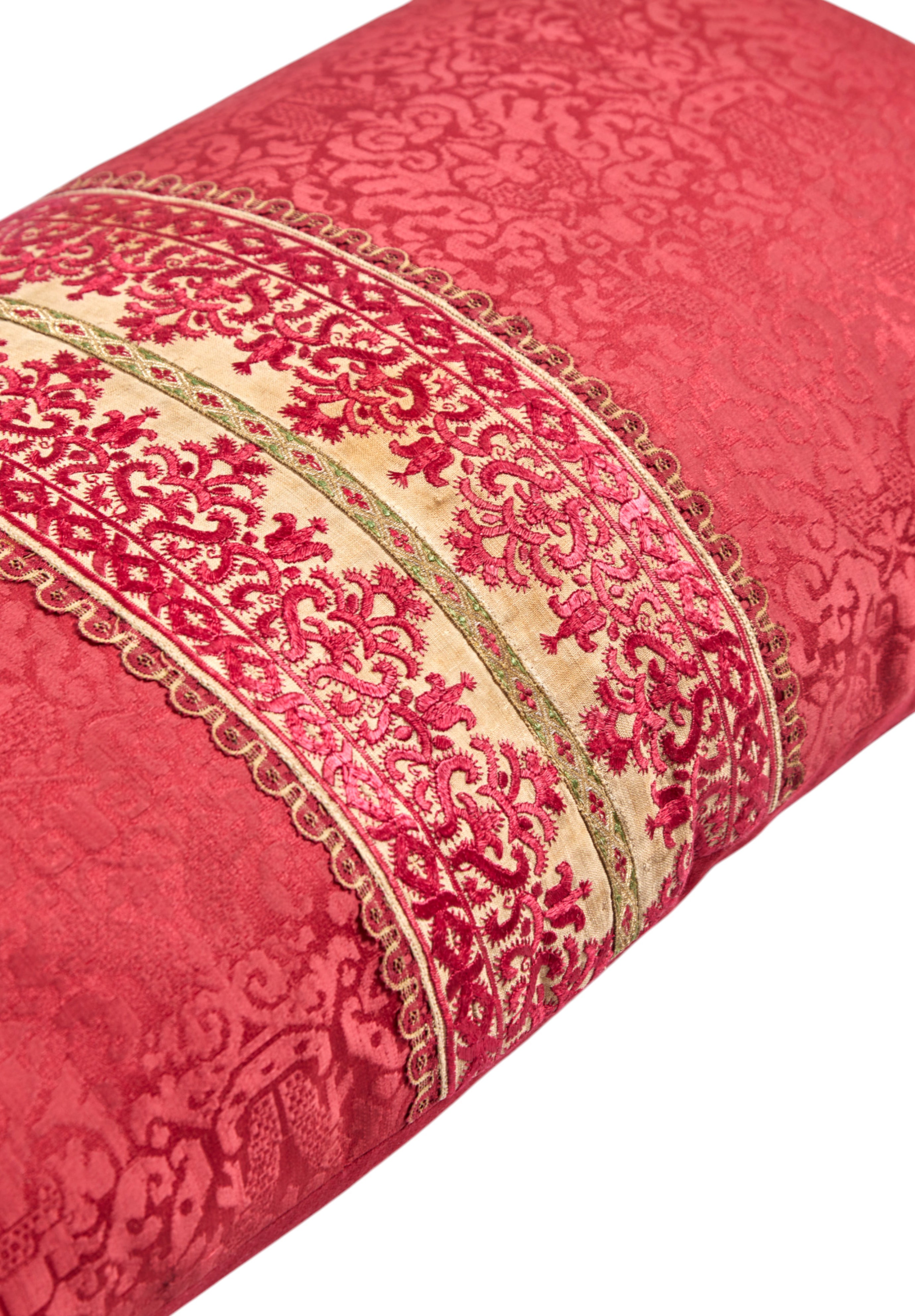 A long oblong cushion in a scarlet silk damask with 18th Century Greek Embroidered silk panel and Italian silk tassles