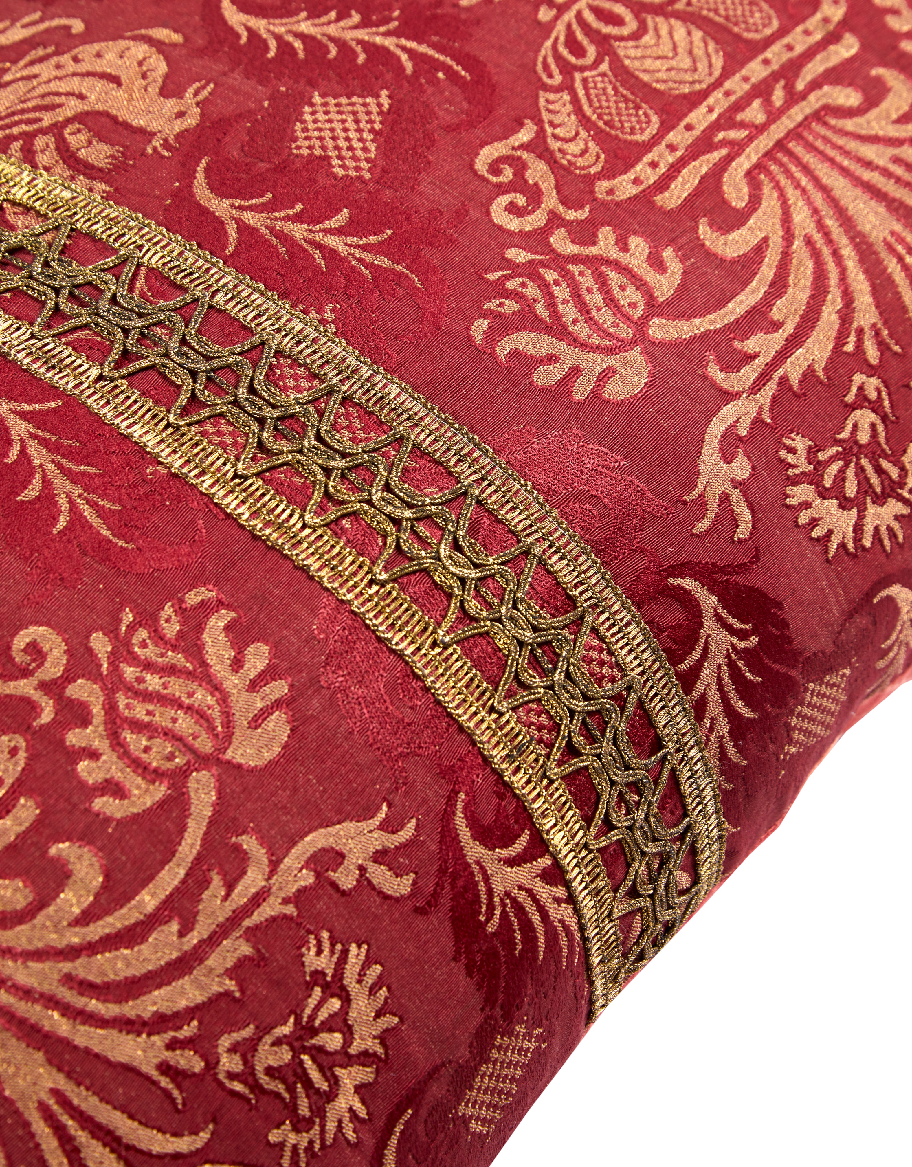 A Claret Bolster Cushion made from antique woven damask with an 18th Century trim