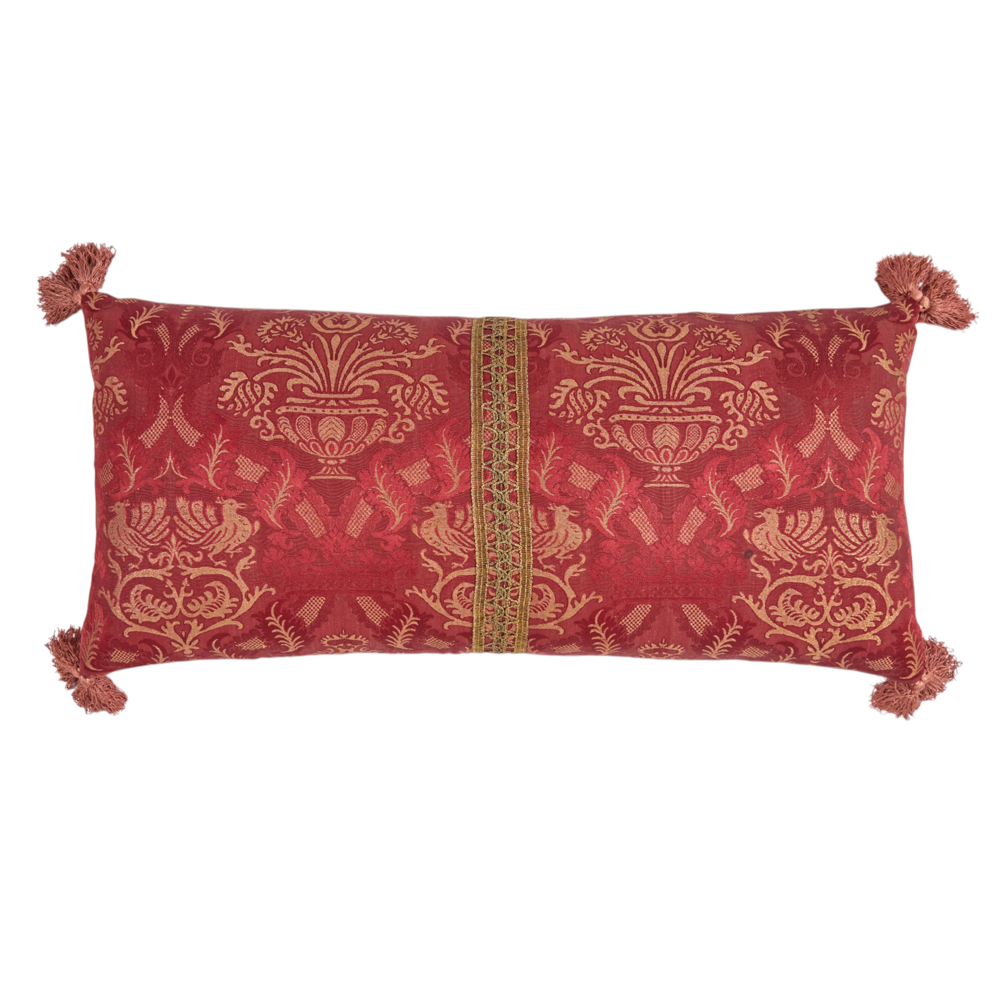 A Claret Bolster Cushion made from antique woven damask with an 18th Century trim