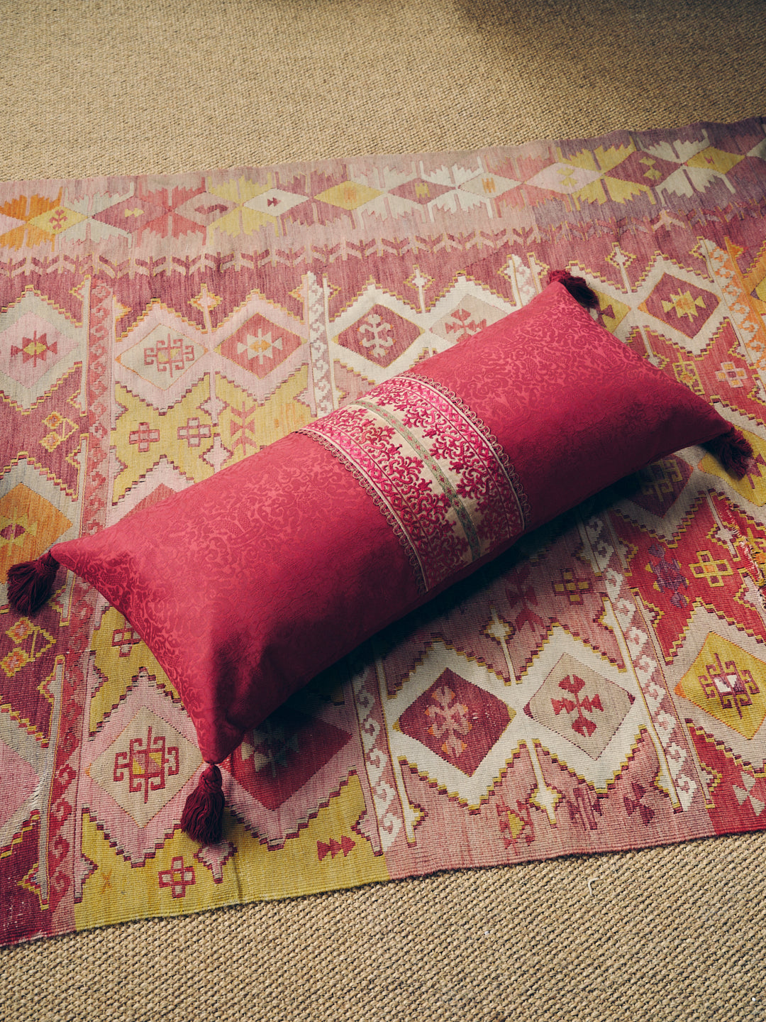 A long oblong cushion in a scarlet silk damask with 18th Century Greek Embroidered silk panel and Italian silk tassles