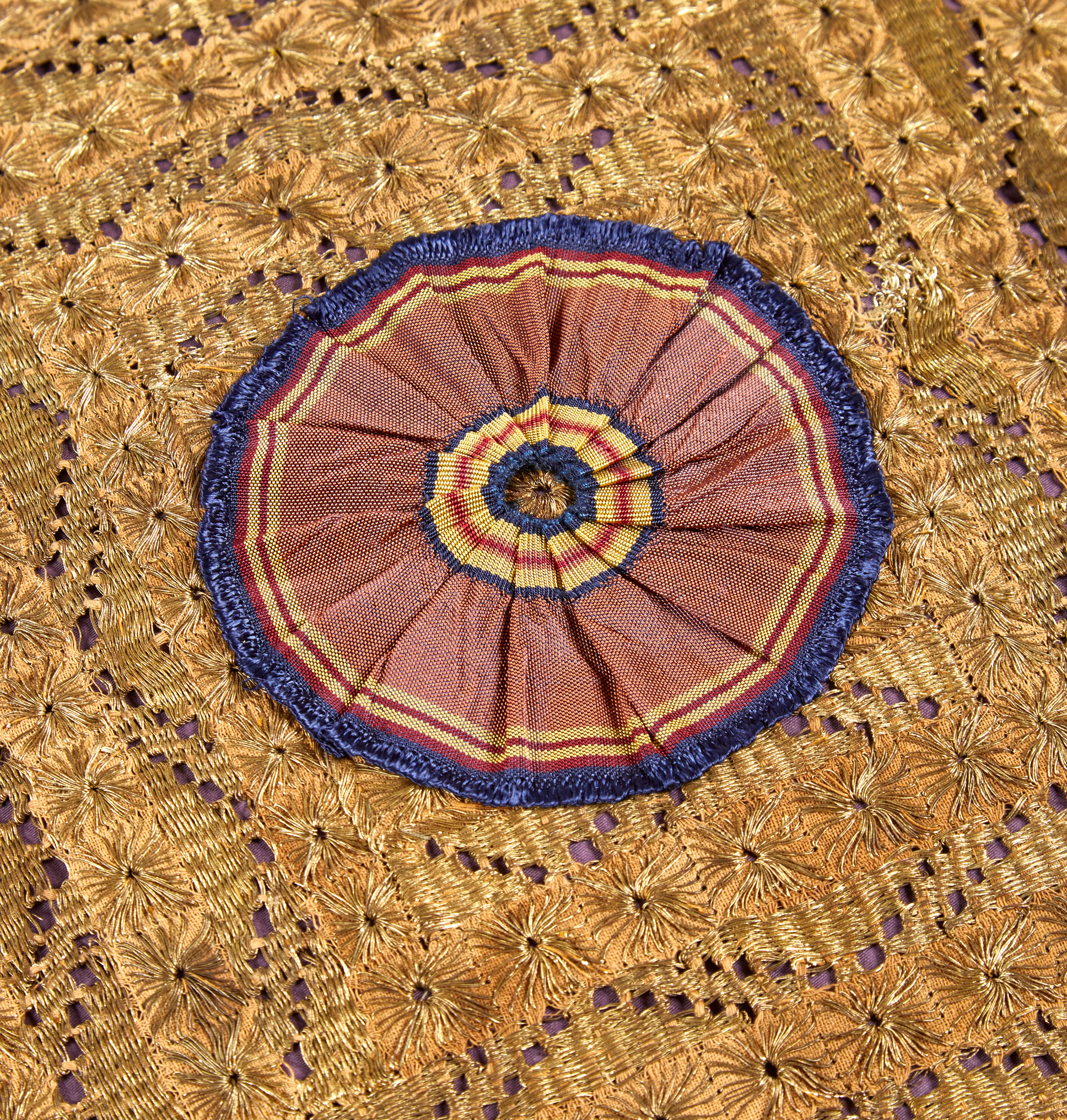 A large Old Gold cushion made with a rare 19th Century Ottoman panel with a handmade silk antique ribboned rosette and Italian silk tassels