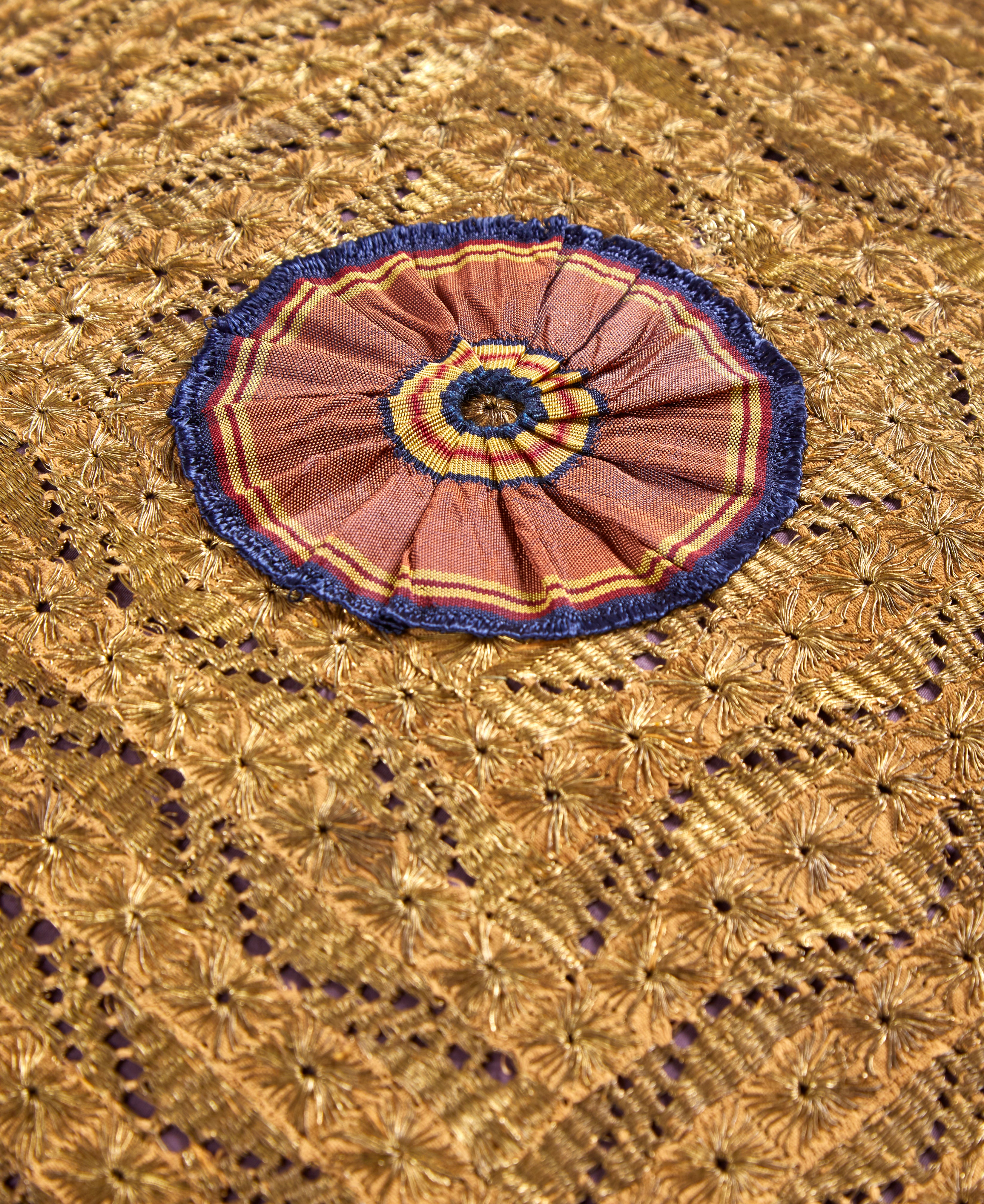 A large Old Gold cushion made with a rare 19th Century Ottoman panel with a handmade silk antique ribboned rosette and Italian silk tassels