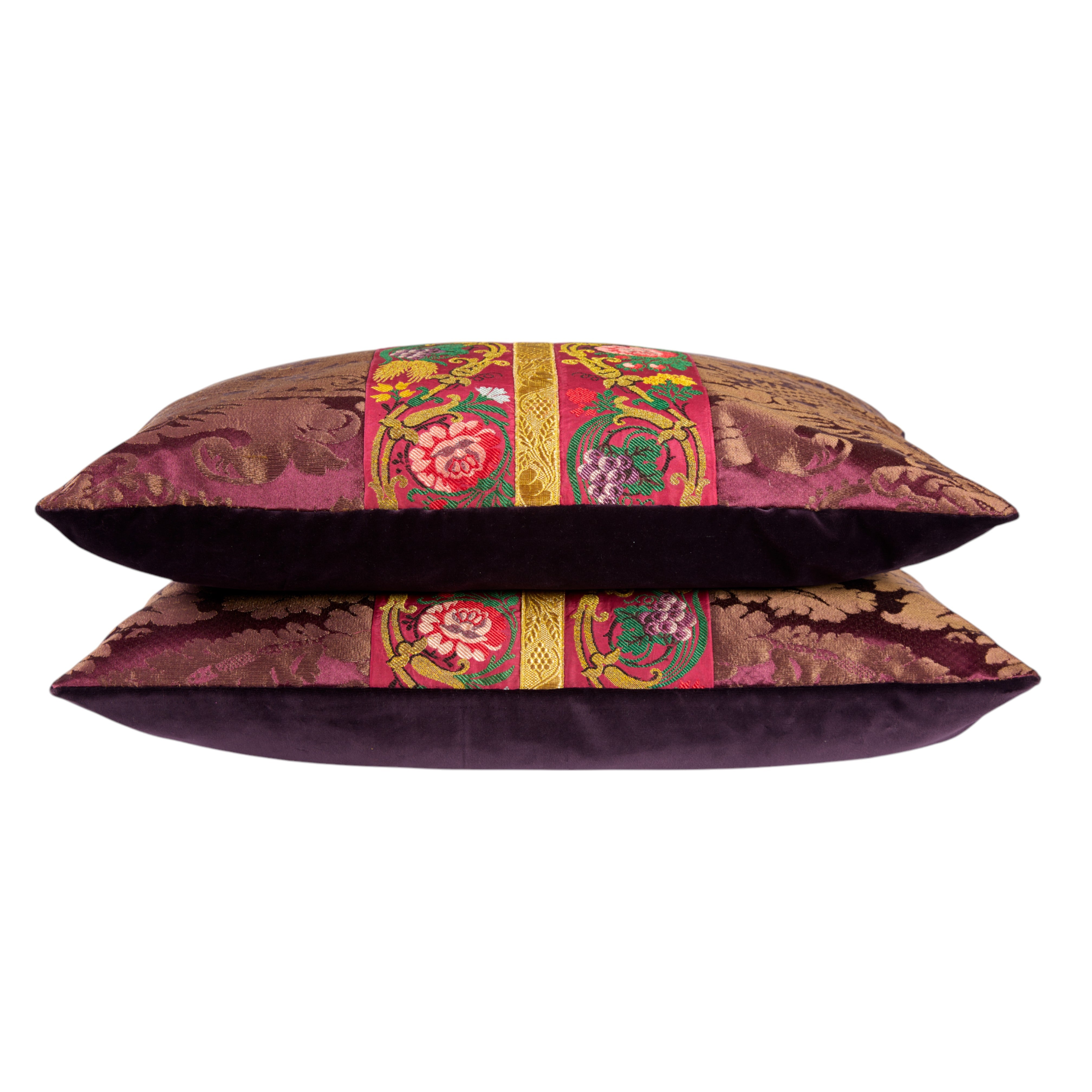 A pair of aubergine silk damask cushions with a central 19th Century embroidered trim