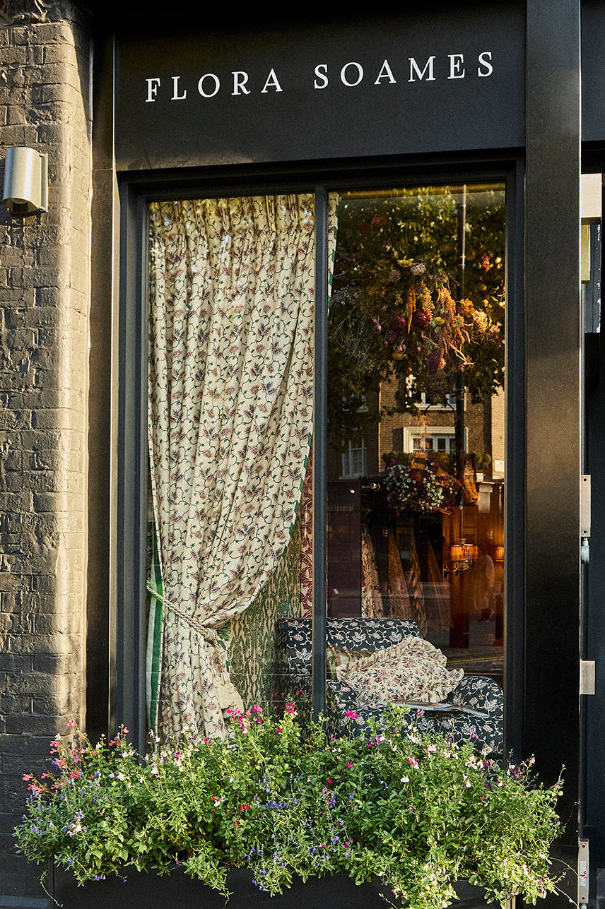A single curtain in West House Trellis Warmer with Plain Stripe Emerald lining&nbsp;
